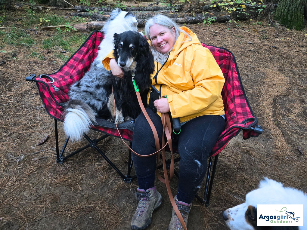 women sitting in camp chair hugging a dog